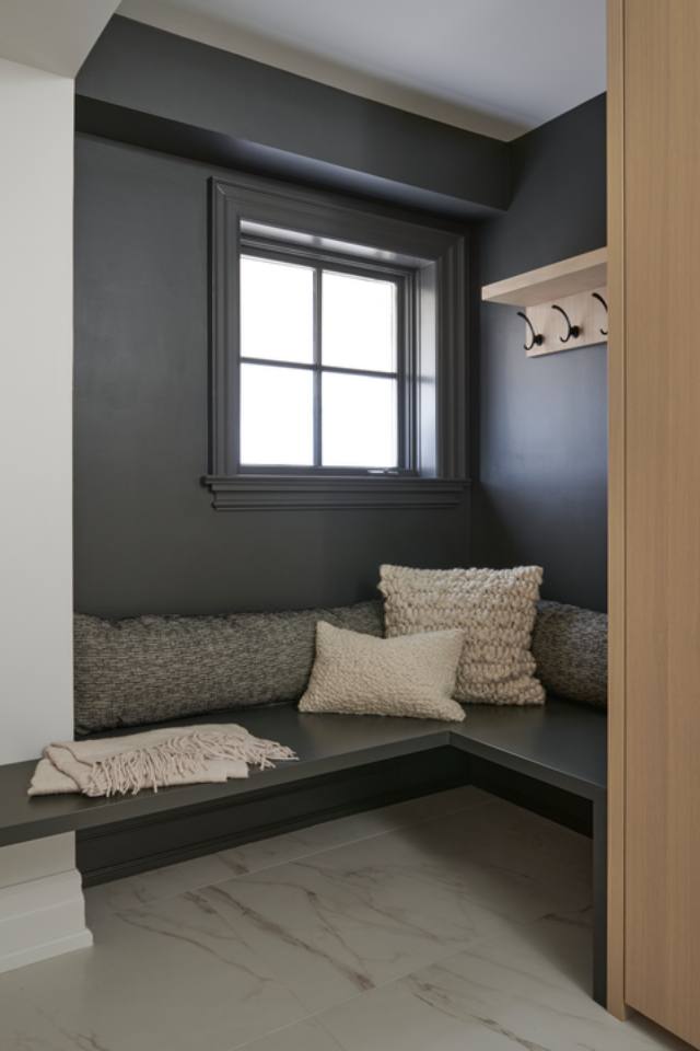 mudroom with black walls and marble tile floors